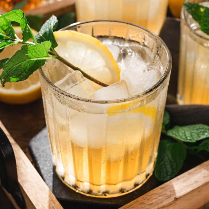 A tray filled with bourbon smash drinks garnished with mint sprigs.