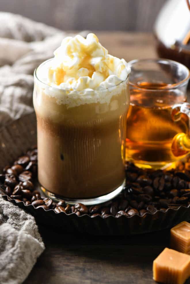 Small glass of coffee topped with whipped cream and caramel sauce.