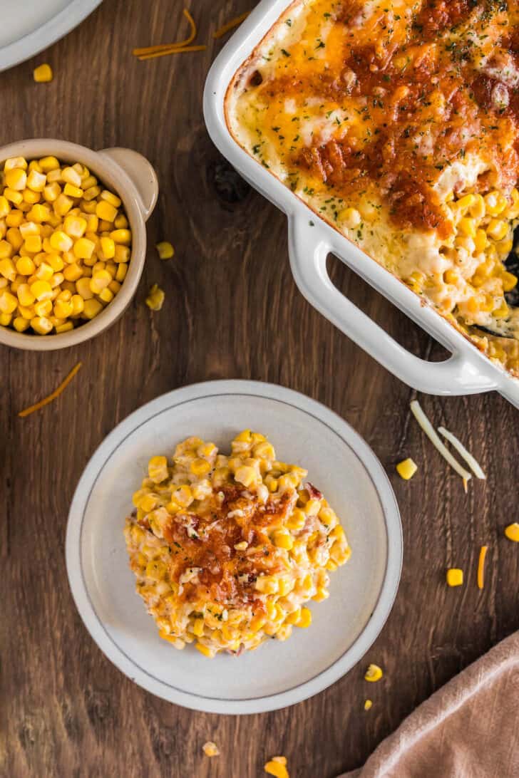 A small plate filled with a sweetcorn bake, next to a baking dish.