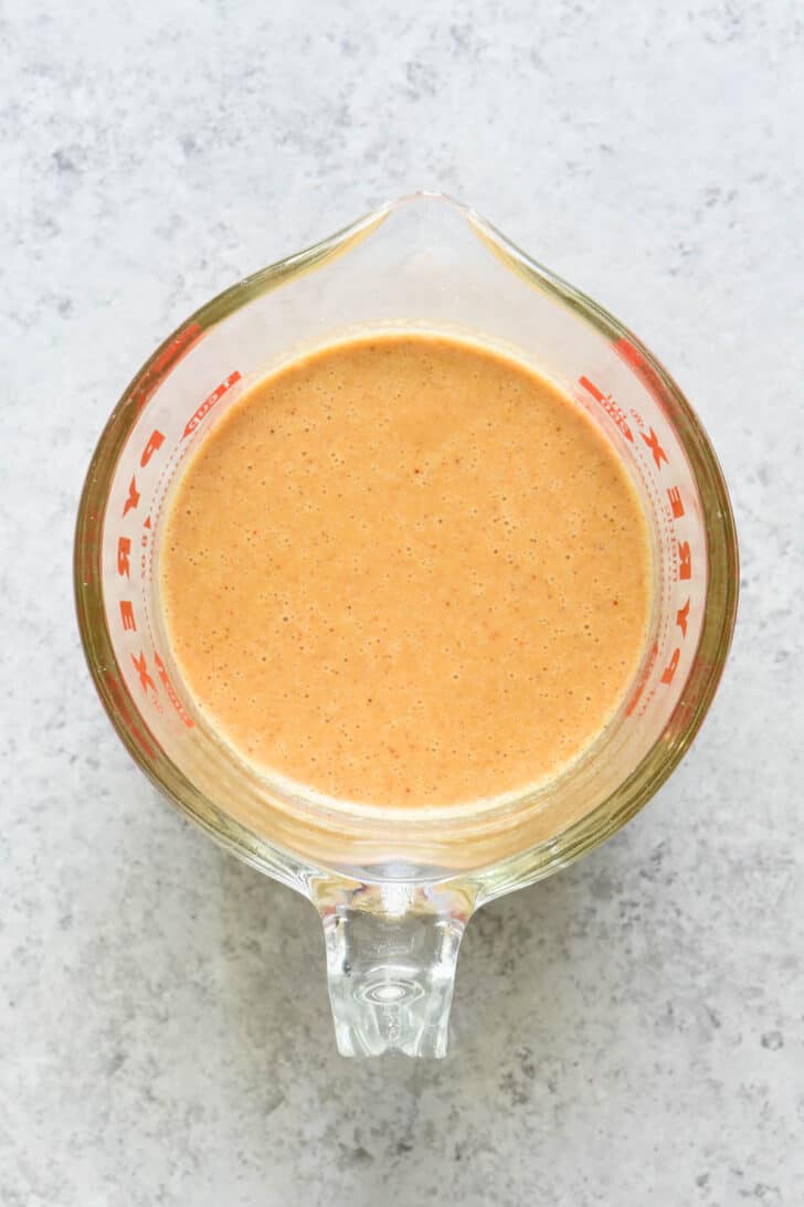 Orange liquid in a glass Pyrex measuring cup.