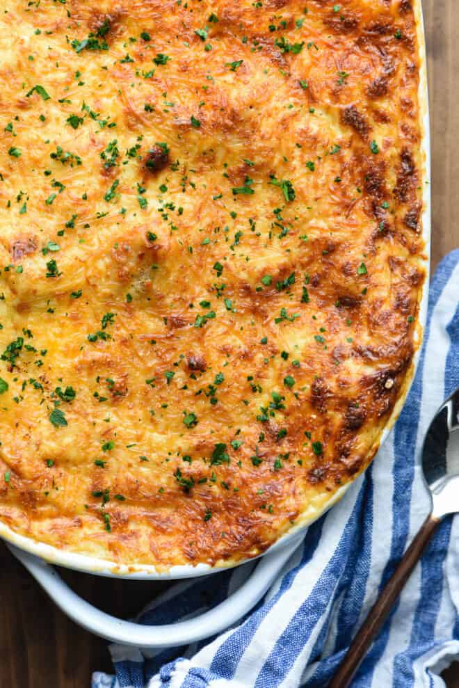 Overhead view of oval baking dish with cheese-topped baked pasticio.