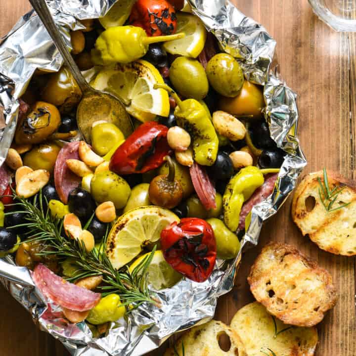 Fill a foil packet with olives, peppers, nuts and salami and throw it on the grill! This Grill-Roasted Antipasto will be the easiest summer appetizer you'll ever make! | foxeslovelemons.com