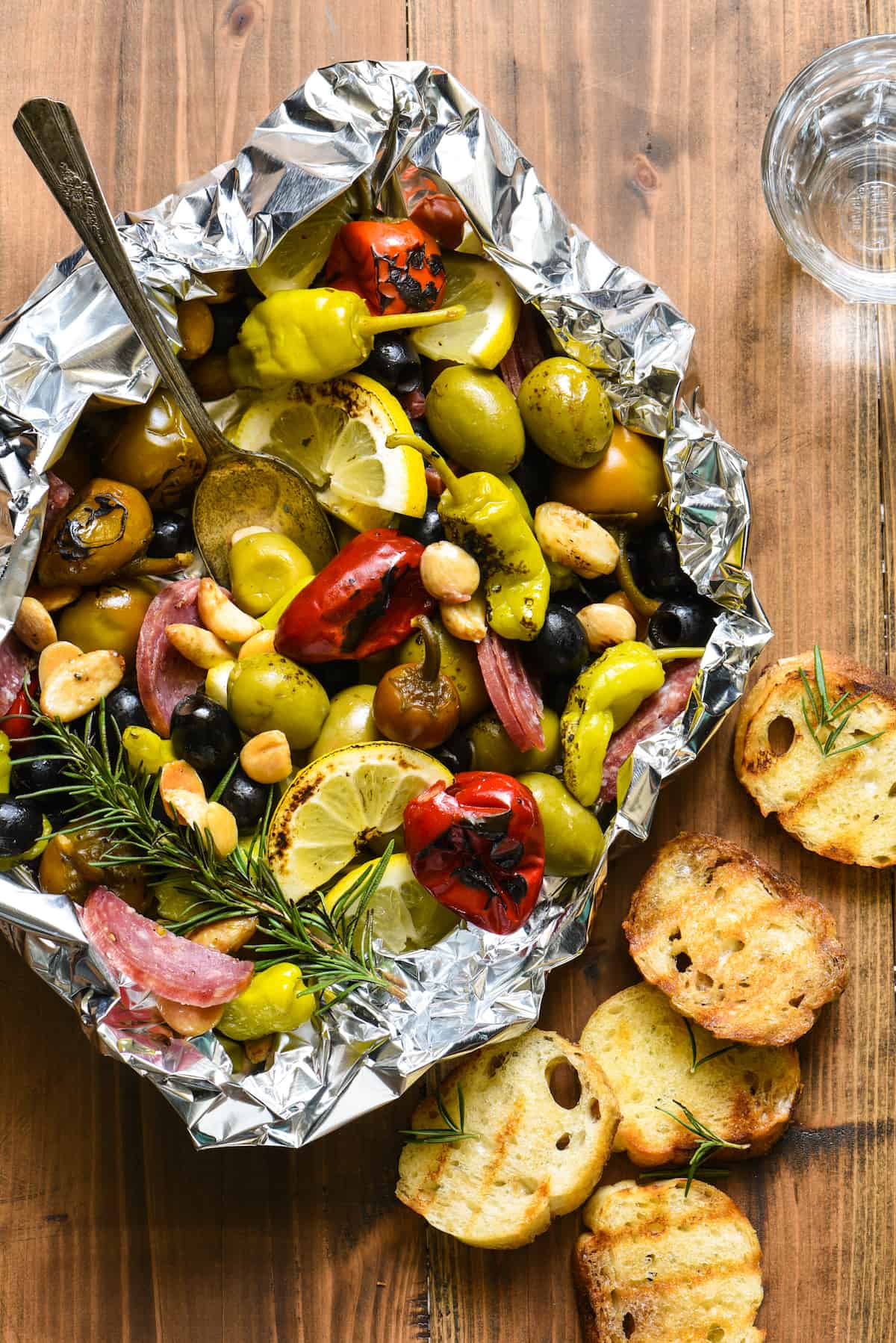 Fill a foil packet with olives, peppers, nuts and salami and throw it on the grill! This Grill-Roasted Antipasto will be the easiest summer appetizer you'll ever make! | foxeslovelemons.com