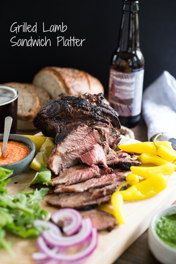 Grilled Lamb Sandwich Platter - Change up your grilling game with a boneless leg of lamb! It cooks in the same amount of time as a thick steak, and has a rich delicious flavor. Pile sandwich fixings, zesty feta spread, chimichurri and rye bread onto a big board, and dinner is served! | foxeslovelemons.com