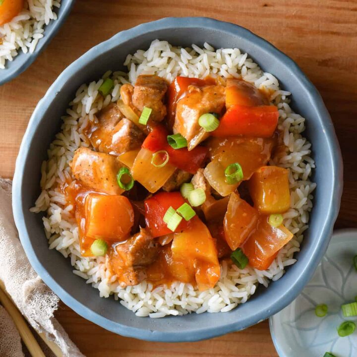 Slate blue bowl filled with white rice and Instant Pot sweet and sour chicken.