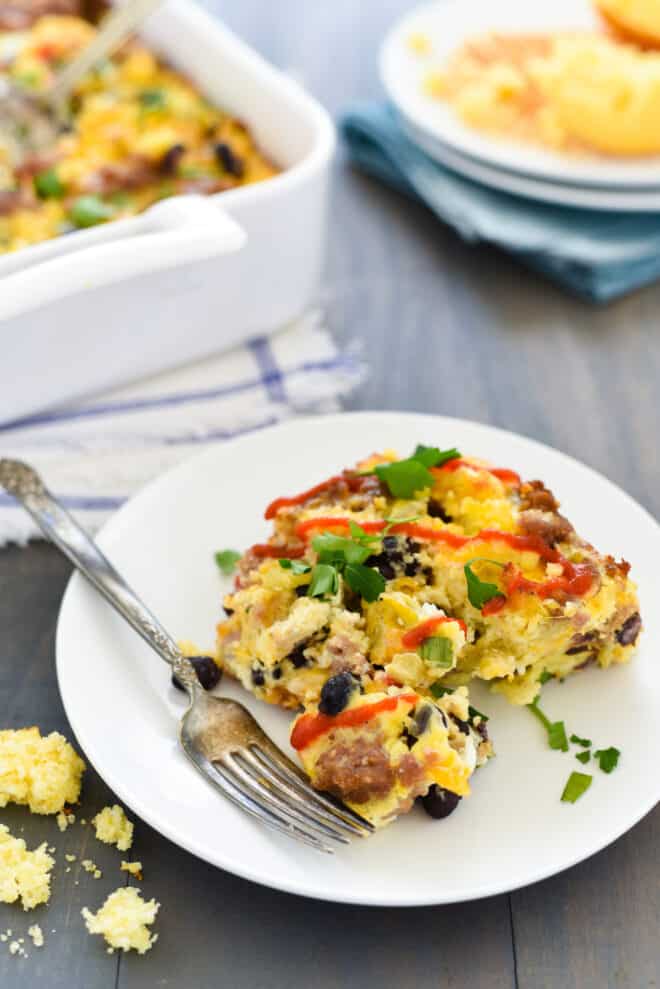 A square piece of sausage cornbread casserole on a small white plate.