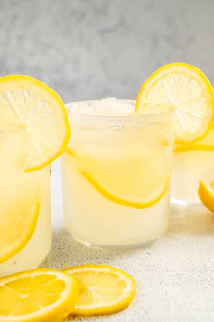 A lemon margarita garnished with a lemon slice on a light surface.