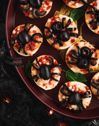 Halloween pizzas made with mini frozen pizza bagels and black olives cut to look like spiders.