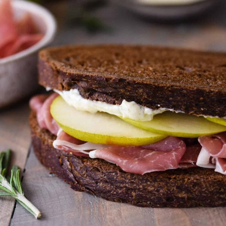 Pumpernickel bread sandwich filled with prosciutto, sliced pears and mayo.