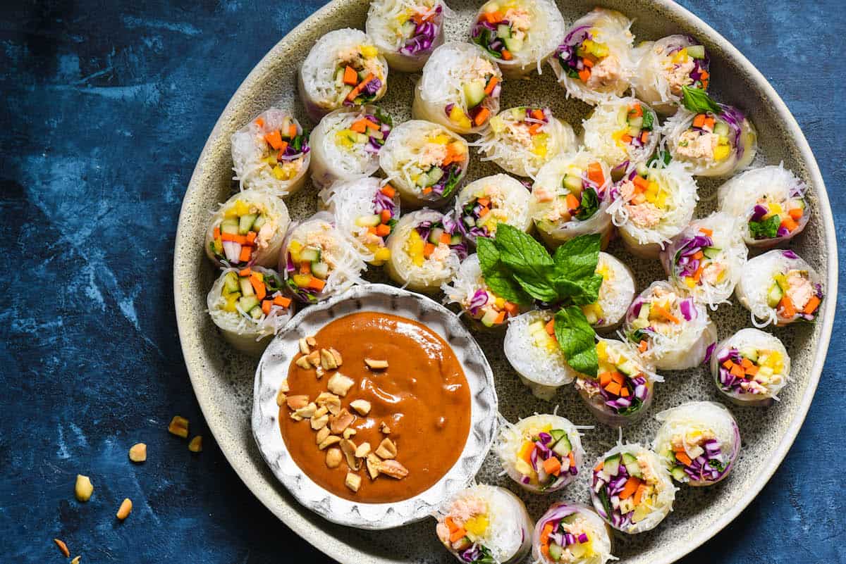 Serve the rainbow with these Salmon Fresh Rolls with Spicy Peanut Sauce. Perfect as a bright party appetizer or healthful dinner, be a "home chef" and make this takeout-inspired recipe at home! | foxeslovelemons.com