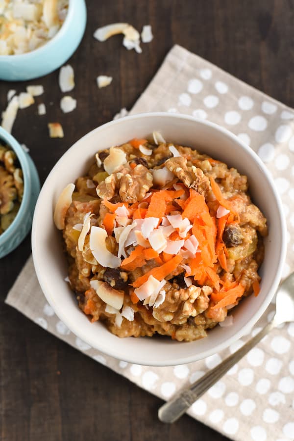 Closeup of carrot cake oatmeal in white bowl on top of polka dot napkin.