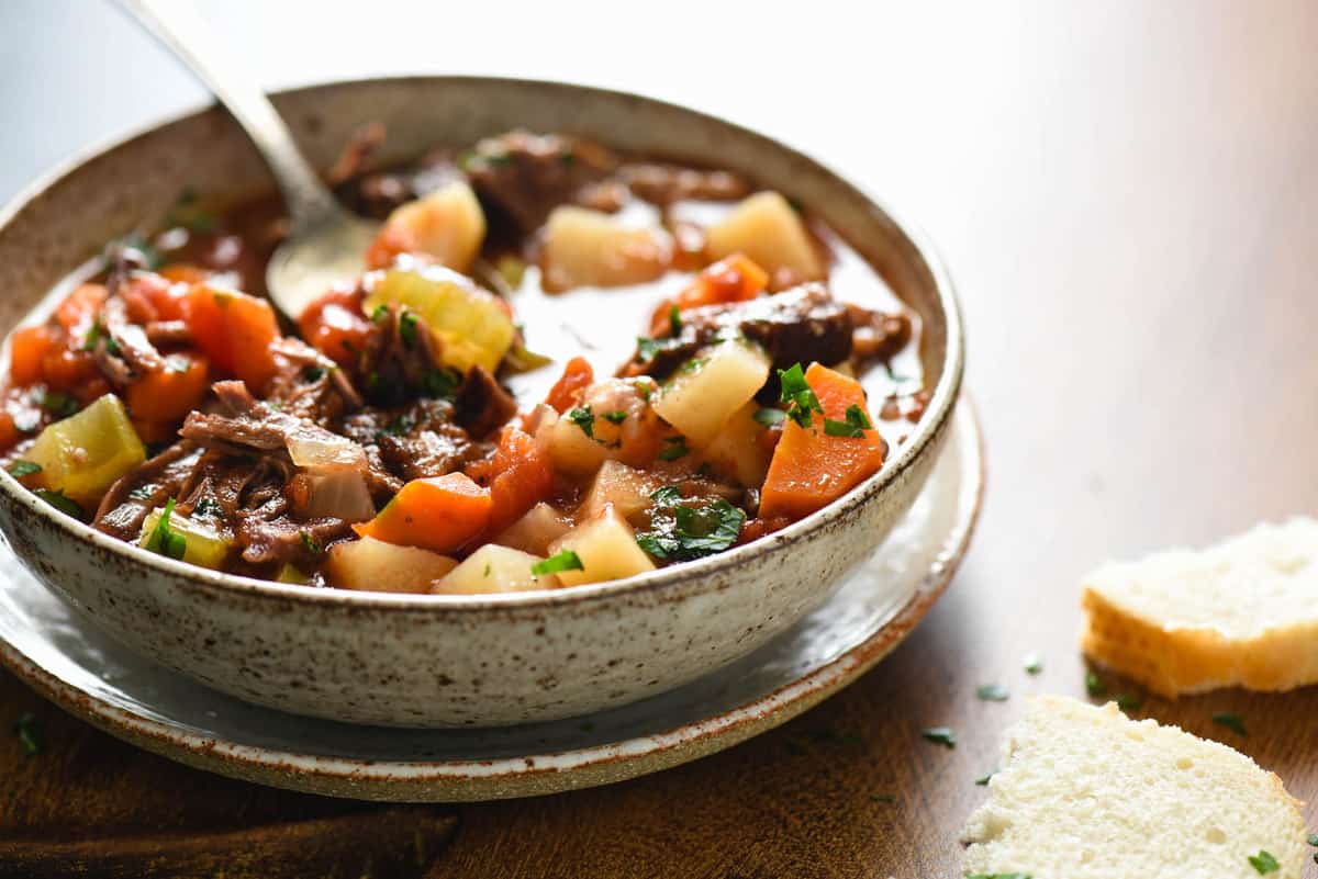 Bowl of vegetable beef soup with spoon in it.