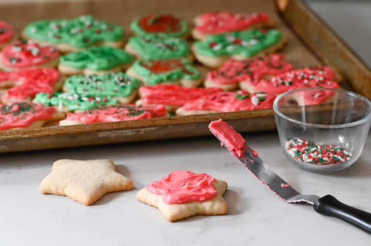 A sour cream sugar cookie recipe in the process of being frosted and decorated.