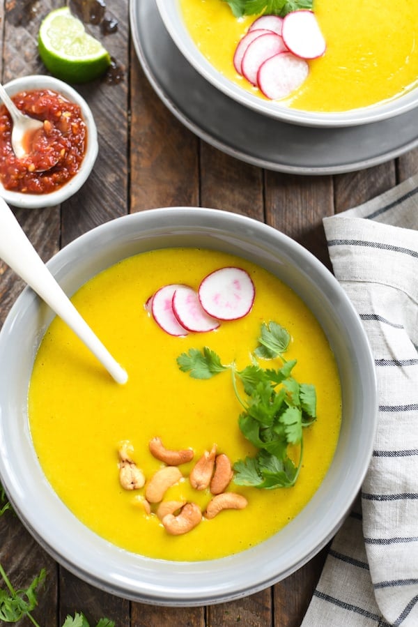 Closeup photo of Thai soup made from potatoes, next to striped linen napkin.