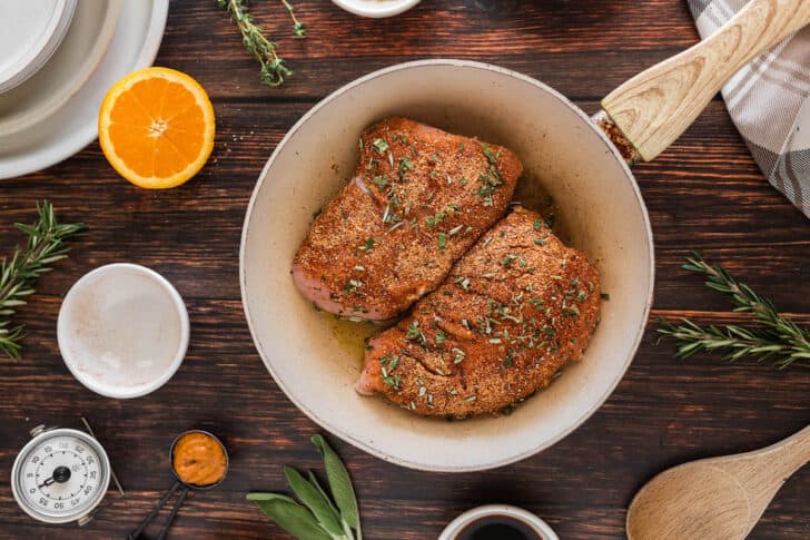 A simple turkey tenderloin recipe being seared in a white skillet.